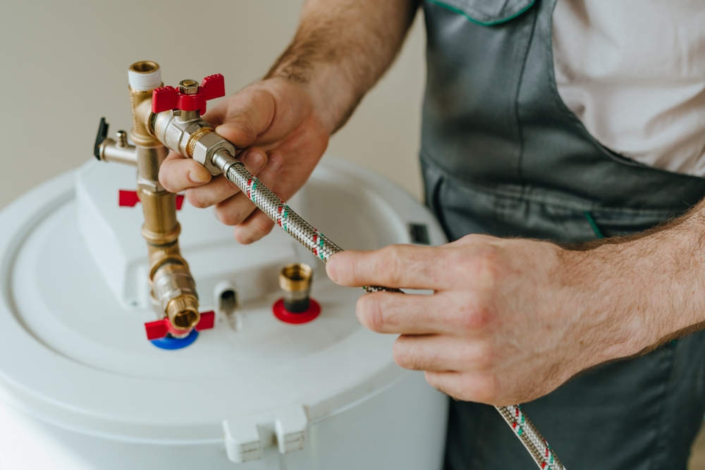 Man fixing water heater. Close-up view of male hands